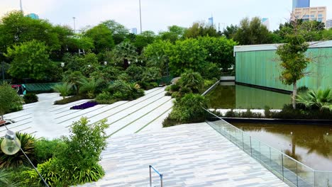 a serene modern landscape featuring white marble walkways, lush greenery, and a reflective pool. perfect for themes of architecture, environment, luxury, and tranquility.