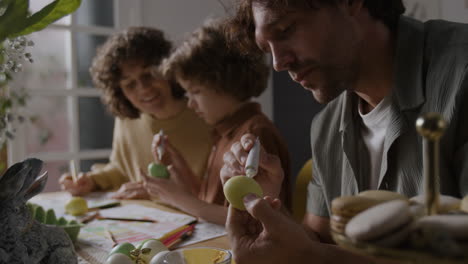 la familia decora el huevo de pascua.