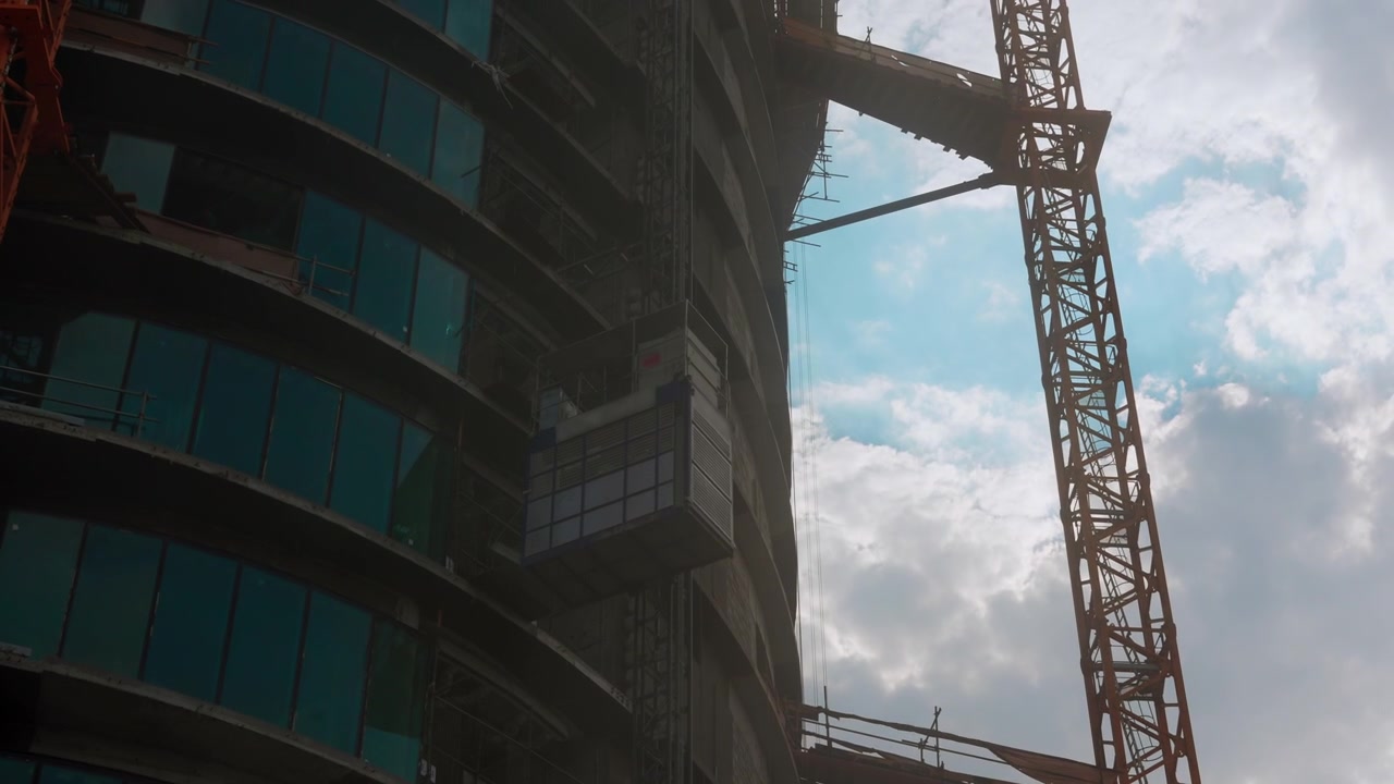 Ascensor de construcción subiendo por el lateral de un rascacielos