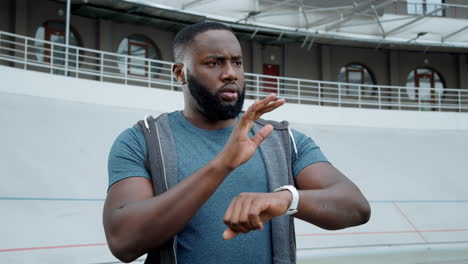 man using smart watch on racetrack