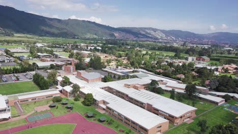 aerial zoom out drone shot of sports center with a running track