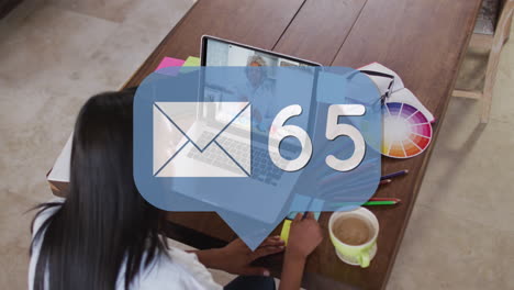 animación de icono de correo y números sobre mujer de negocios biracial usando portátil.