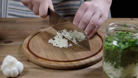 Der-Küchenchef-Schneidet-Knoblauch,-Eine-Grundzutat-Für-Fleischsoße,-Chimichurri-Und-Café-de-Paris-Butter