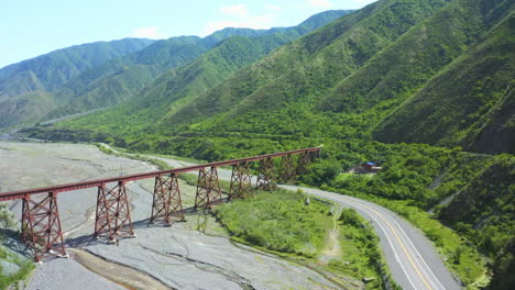 Antena---Toma-épica-De-Un-Río-Seco-Con-Un-Puente-Ferroviario-En-La-Parte-Superior-Y-Una-Autopista-Al-Lado