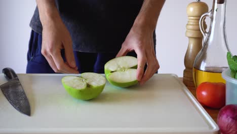 A-Piece-Of-Unpeeled-Green-Apple-Being-Cut-On-Cubes-Using-Sharp-Kitchen-Knife