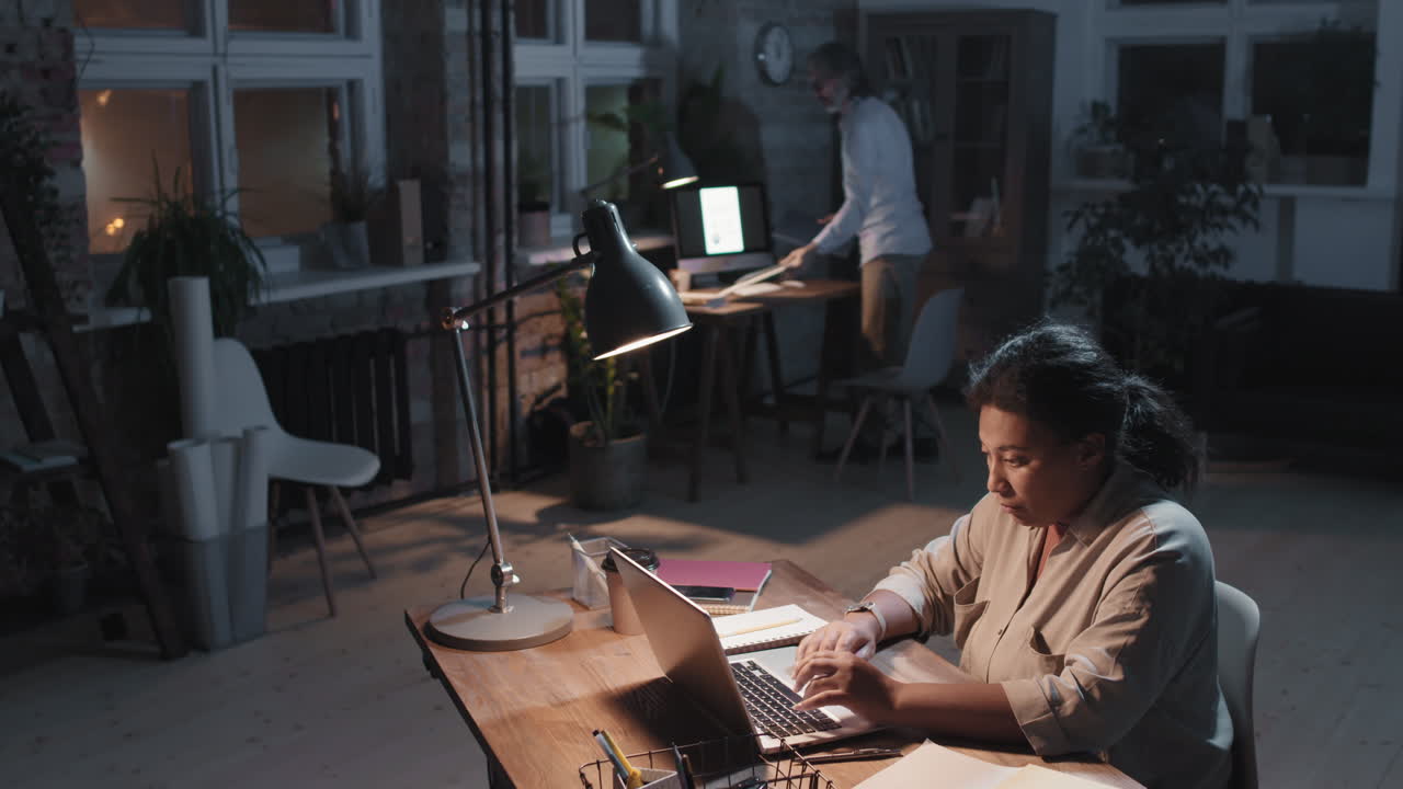 Colleagues working late in a dimly lit office