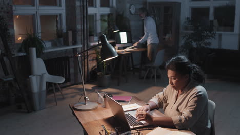 colleagues working late in a dimly lit office