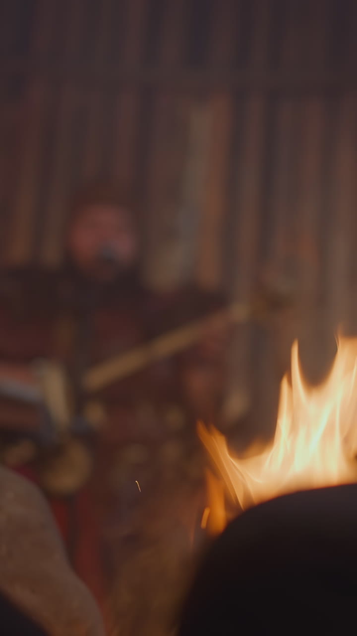 Folk music band performs on ail house stage focus on burning campfire. Rock band conducts atmospheric concert. Siberian art and lifestyle