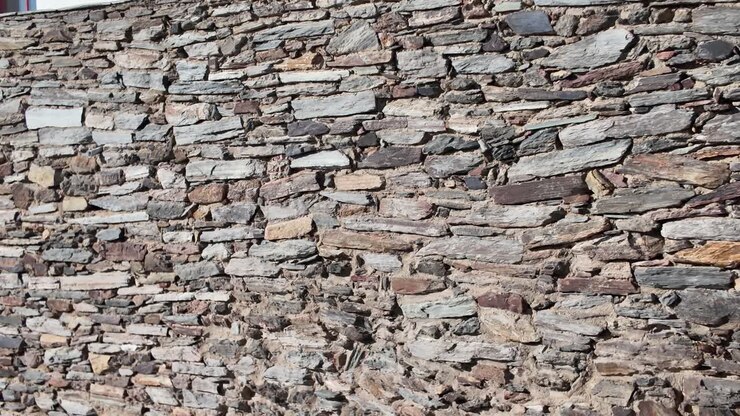 Aged layered stone detail from historic castle wall in Monsaraz Portugal
