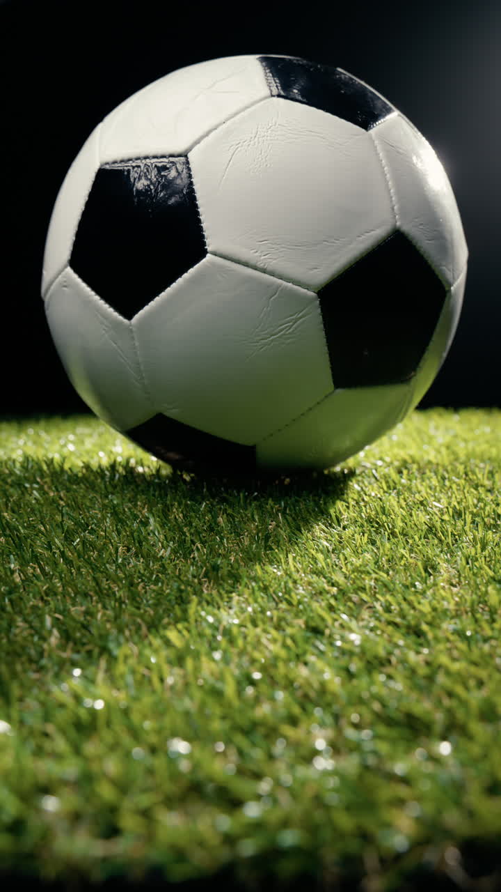 Gece çim sahada yavaşça dönen futbol topu