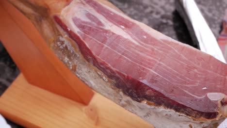 Close-up-female-mid-age-hands-preparing-ham-leg-for-slicing-uncovering-cut