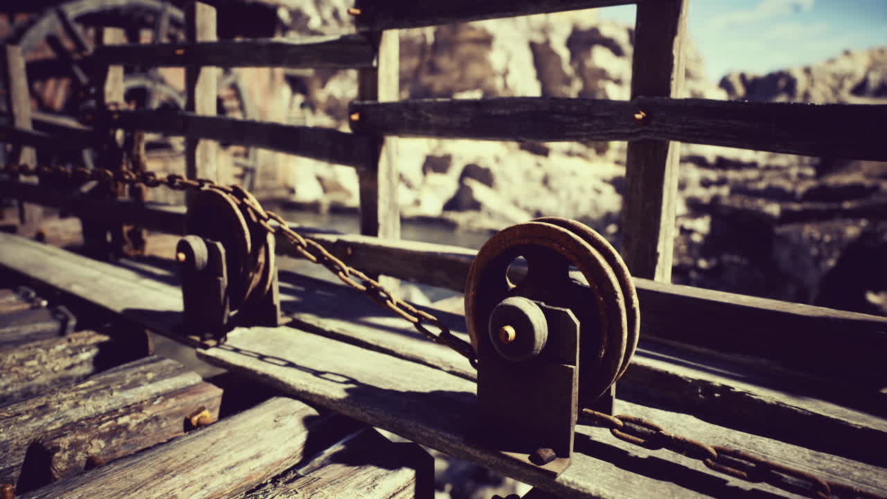 Chain mechanism on wooden structure by rocky terrain under clear sky