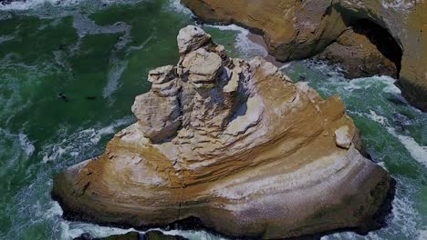 top down view with slow tilt up over la catedral rock along the coastal cliffs of peru, south america