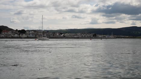 Small-yacht-boat-floating-on-British-rural-fishing-town-coastline-morning-tide