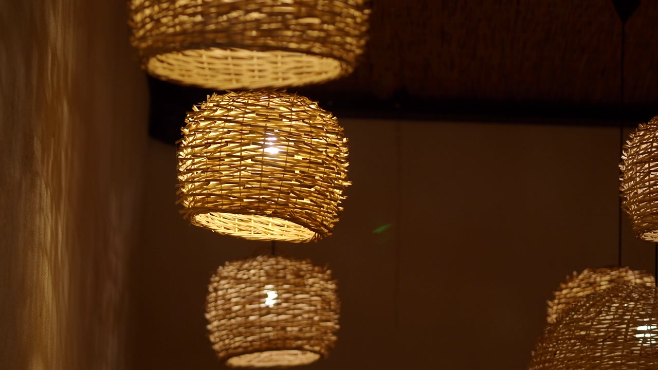 Woven Wicker Lamps Hanging and Glowing with Warm Light