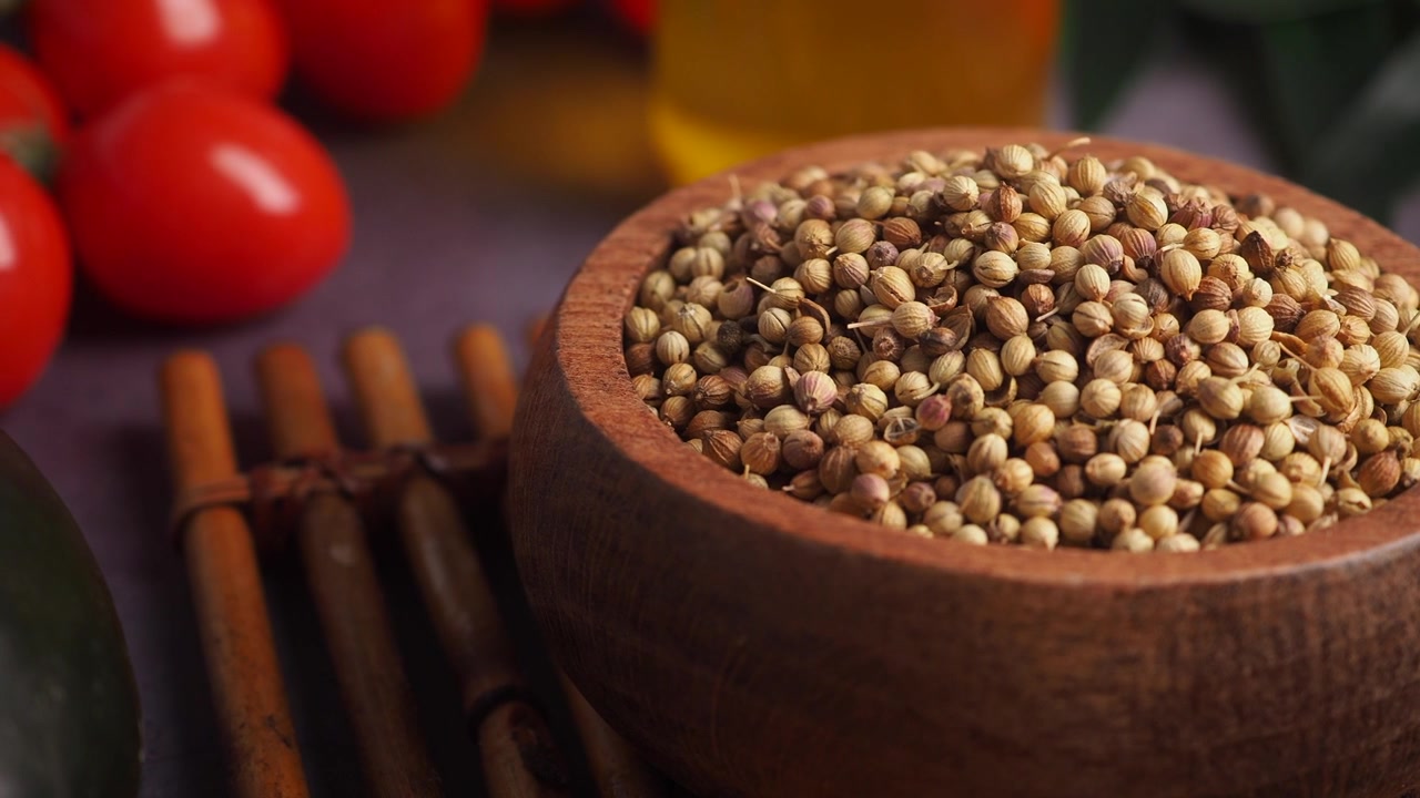Primer plano de semillas de cilantro secas en un cuenco de madera.