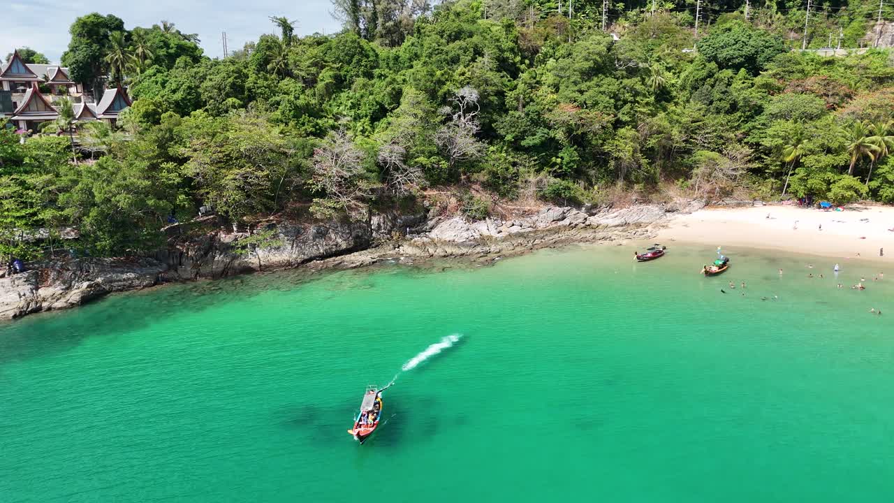 las imágenes de drones capturan una vibrante escena de barcos navegando en aguas turquesas cerca de una exuberante playa tropical en phuket, tailandia.