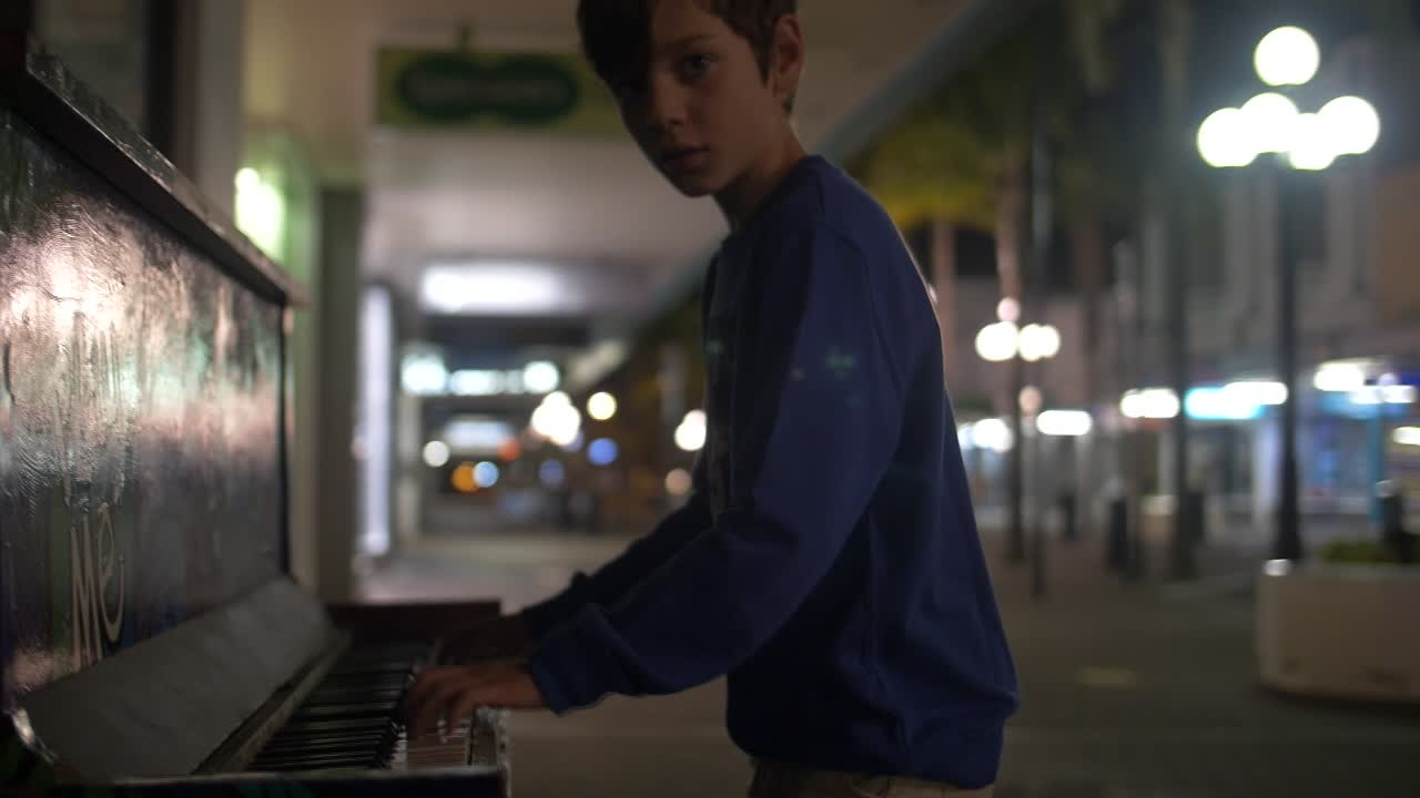 niño toca el piano en la calle