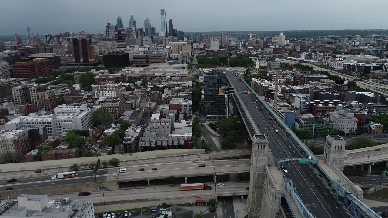Aerial footage panning upwards over the Delaware River and Race Street Pier, revealing center city Philadelphia on a cloudy day. The Ben Franklin Bridge is also in view.