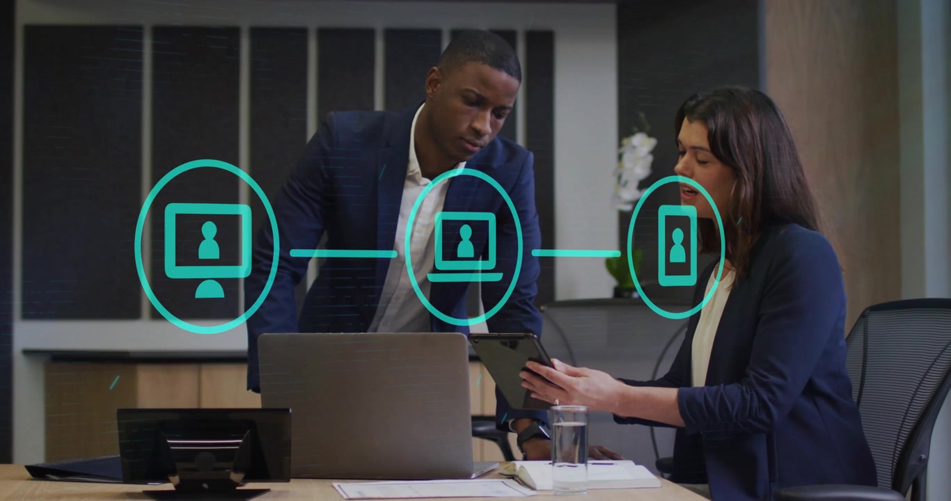 Coworkers entering room swiping tablet, technology diagram fading, linking icons into user profiles