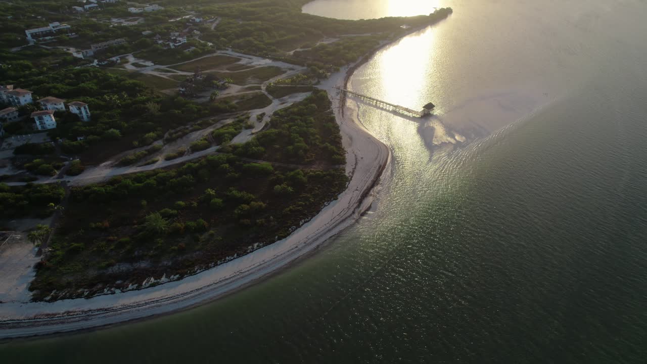 órbita sobre la playa de punta cocos en holbox con el reflejo del sol en el agua, méxico