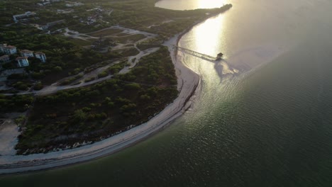 Orbit-over-Punta-Cocos-Beach-in-Holbox-with-Sun-Reflection-on-the-Water,-Mexico