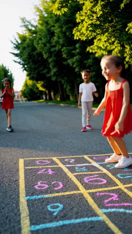 children playing hopscotch on a sunny street