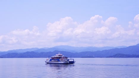 Ferry-swimming-into-the-Distance-with-Mountains-on-the-Horizon-in-Costa-Rican-Landscape-on-Sunny-Day-with-cloudy-Sky