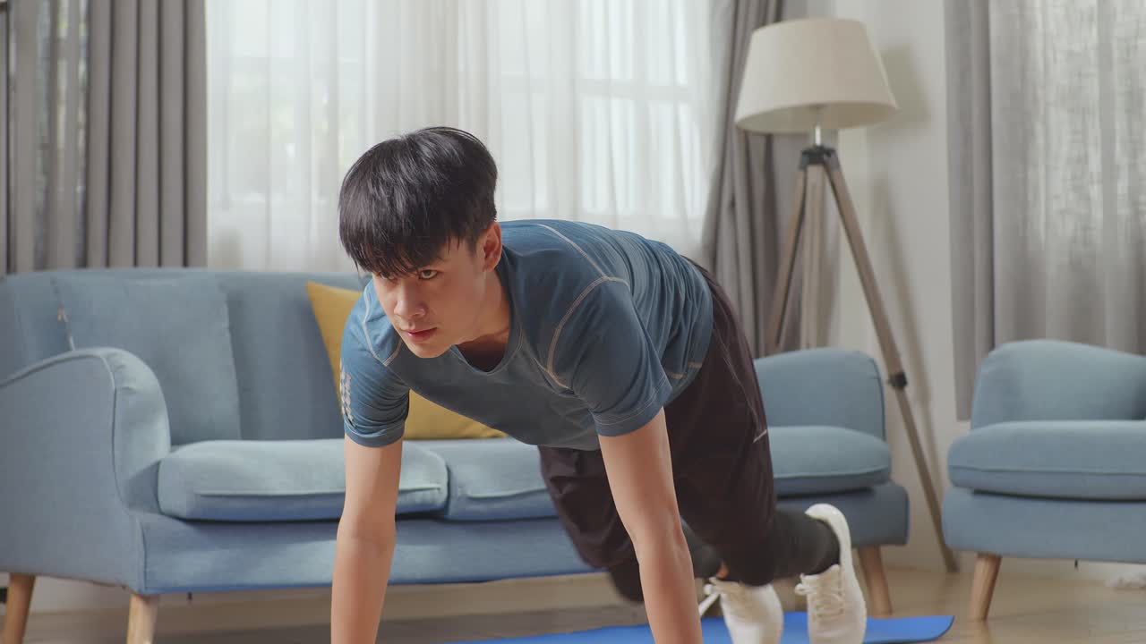 아시아의 피트니스 남성이 집에서 산악 등반 운동을 하고 있습니다.