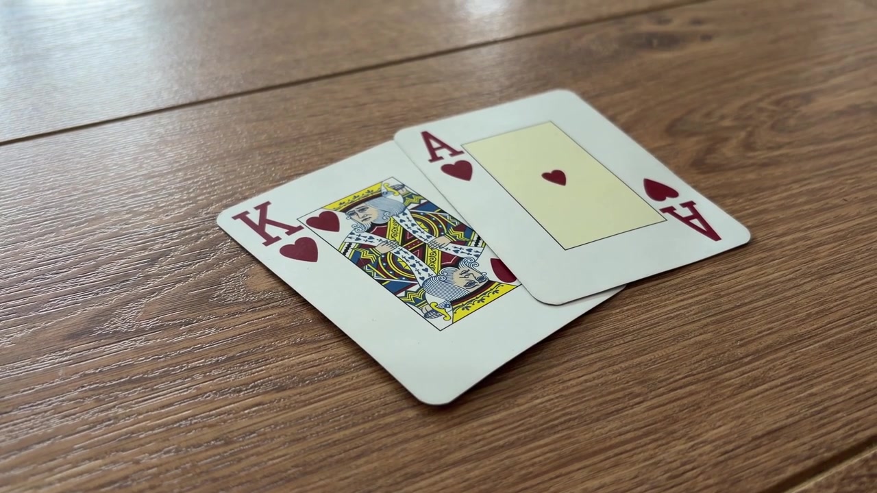 Hrací karty pro Blackjack rozdané na dřevěném stole pro kasinovou hru.