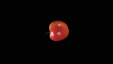 red apple spinning on a black background