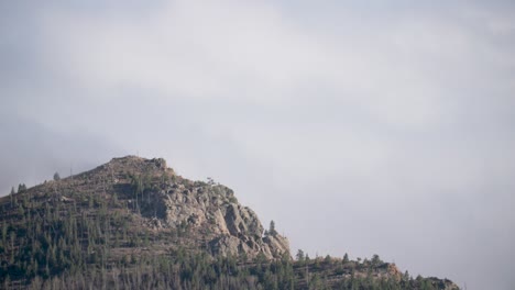 mountain peak points into surrounding inland fog above boulder, colorado