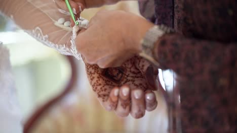 woman adjusting brides wedding dress sleeves