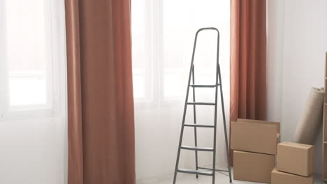 moving boxes and ladder in empty room of new home 1