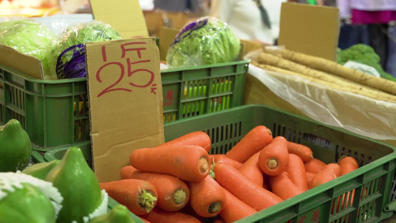 zanahorias naranjas brillantes frescas en un mercado de verduras, filmación documental, puesto de vendedores en taipei, taiwán
