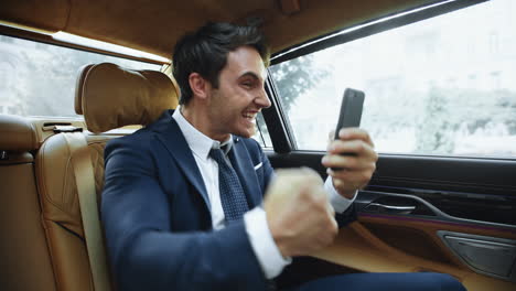 hombre de negocios emocionado teniendo éxito en la reunión en línea en el coche de negocios.
