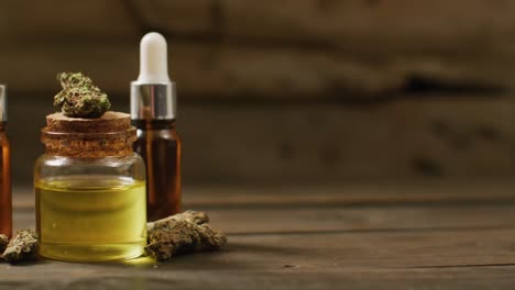 Video-of-marijuana-buds-and-bottles-of-cbd-extract-on-wooden-background