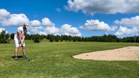 hombres disfrutan de un juego de golf en el campo verde, cielo nublado de verano en letonia