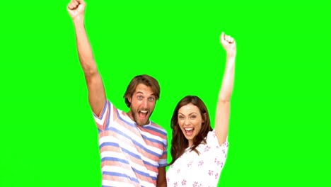 Two-friends-raising-their-arms-on-a-green-screen