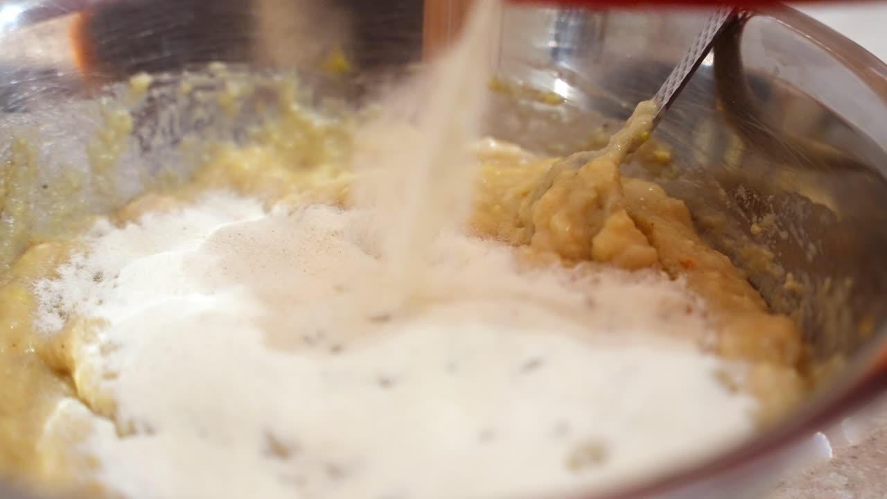 Final mixing stage of chicken meatball batter as ingredients combine into uniform mass, flour added
