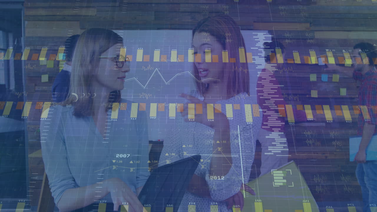 Discussing financial data charts, businesswomen using animation in office meeting