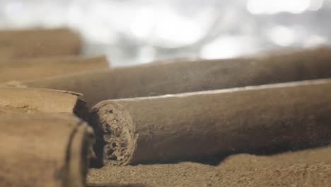 extreme close-up shot cinnamon sticks fall on table, spice concept, super slow motion