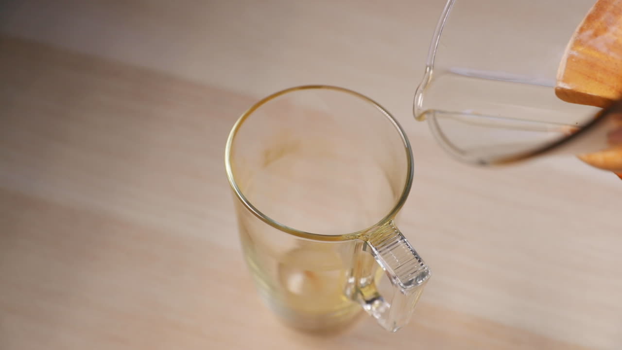 120fps의 슬로우 모션 캡처로 커피를 부어 캡처한 키가 큰 유리에 전면과 상단에서 볼 때 나무 손잡이가 있는 유리 프렌치 프레스에서 커피를 붓는 것