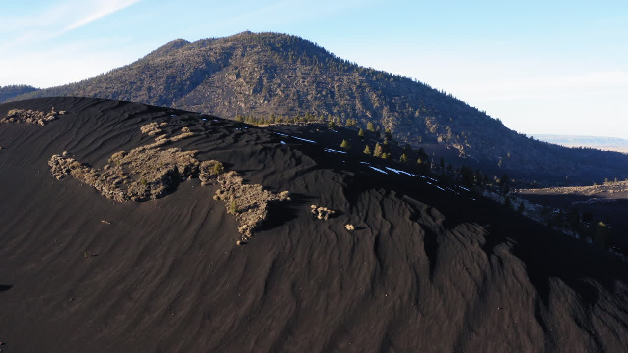 일몰 분화구에 화산이 있는 검은 모래 언덕, 깃대 - 공중 드론 비행