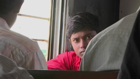 a young man rides on a train in india