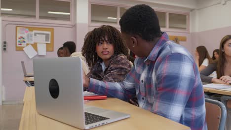 Students collaborating on a laptop in the classroom