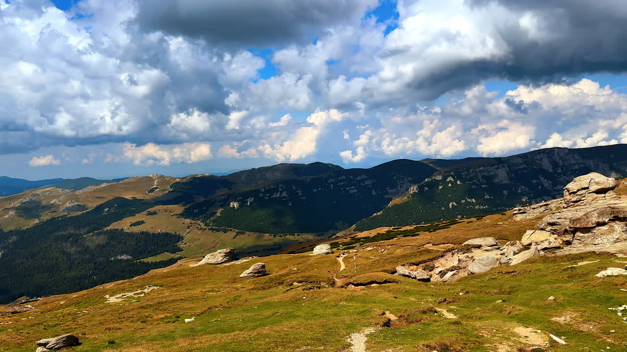 Scenic panorama from a high mountain edge. The view extends over the valley towards distant horizons