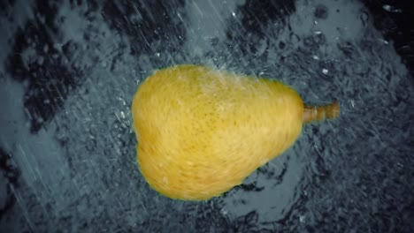 pera con salpicaduras de agua clara sobre un fondo negro. super bucle de cámara lenta.