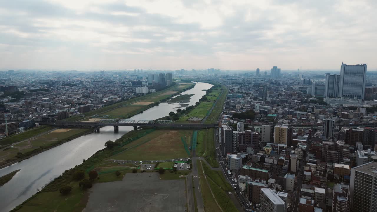 Aerial establishing view of Musashi Kosugi and Tama River under haze