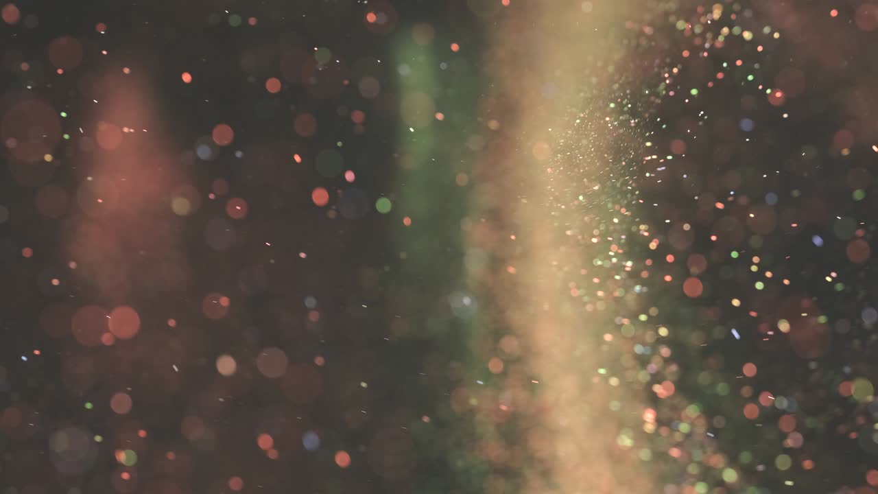 The colorful particles floating on the dark background. slow motion